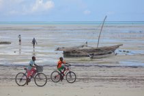 Jungen fahren Fahrrad am Strand von Sansibar — Stockfoto