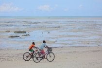 Ragazzi Equitazione Biciclette sulla spiaggia Zanzibar — Foto stock
