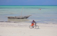 Family Riding Bike on the beach Zanzibar — Stock Photo