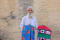 Местный старик продает ткань в Ширазе, Иран — стоковое фото