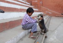 Retrato de pequeno menino indiano e cachorro na rua da cidade . — Fotografia de Stock