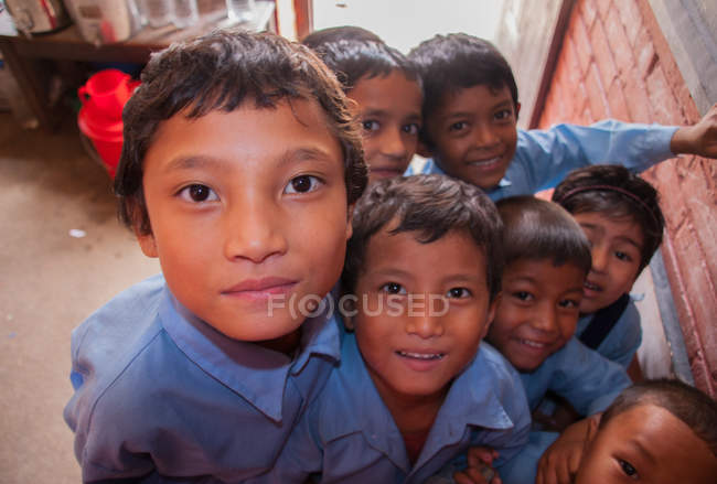 Crianças de uniforme escolar sorrindo para a câmera — Fotografia de Stock