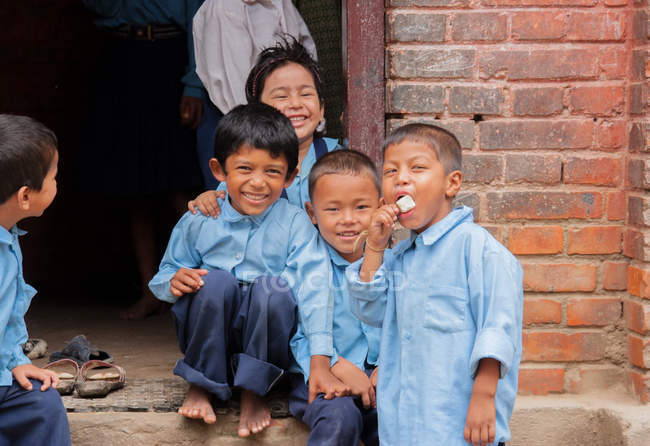 Дети в школьной форме улыбаются в камеру — стоковое фото