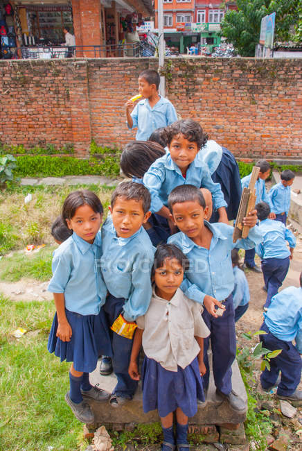 Enfants en uniforme scolaire souriant à la caméra — Photo de stock