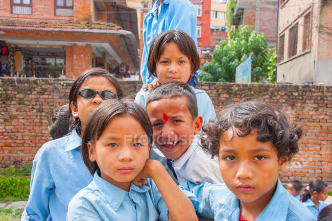 Bambini in uniforme scolastica sorridenti alla macchina fotografica — Foto stock