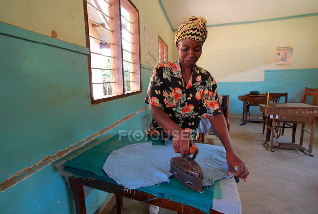 Femme africaine repassage tissu — Photo de stock