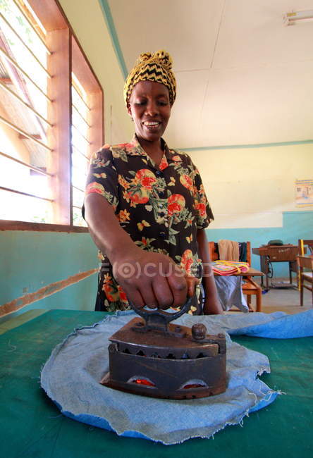 Mujer africana planchando tela - foto de stock