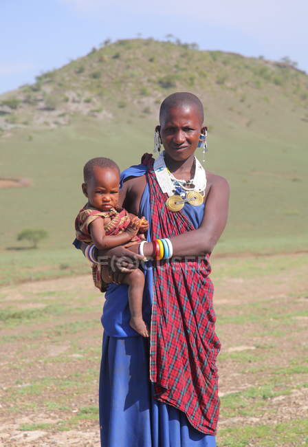 Mujer masai con bebé en ropa tradicional, Tanzania - foto de stock