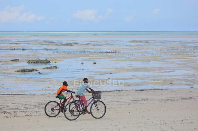 Boys Riding Bikes On The Beach Zanzibar Stock Photo Boys Riding Bikes On The Beach Zanzibar Stock Photo