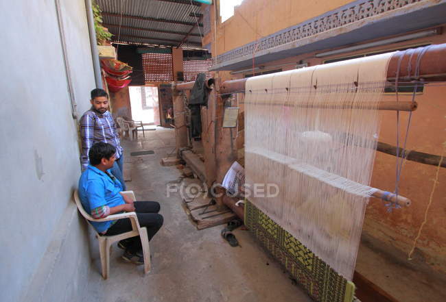 Trabajadores textiles no identificables tejiendo en Ámbar (suburbio de Jaipur). India. Estado de Rajastán - foto de stock