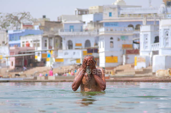 Indian poor man taking bath — Stock Photo