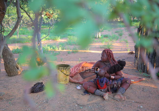 Жінка з дитиною в селі Himba племені — стокове фото