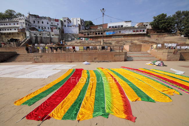 People and Washed clothes drying in sunlight at the ghats in Varanasi, India. — Stock Photo