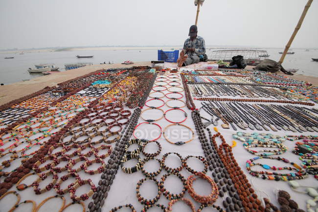 Un hombre local vende recuerdos en la calle Varanasi en Uttar Pradesh, India - foto de stock