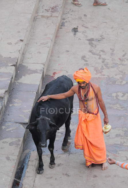 Indischer mann mit kuh auf der straße in indien — Stockfoto