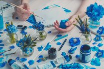 Hands with blue paint brush — Stock Photo