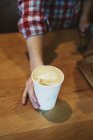 Person stellt eine Tasse frisch zubereiteten Kaffee auf — Stockfoto