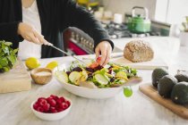 Frau bereitet in der Küche einen Salat zu — Stockfoto