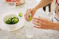 Woman squeezing fresh limes — Stock Photo