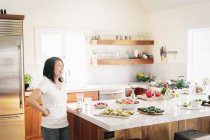 Donna in cucina vicino a un bancone — Foto stock