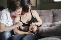 Women playing with their baby girl. — Stock Photo