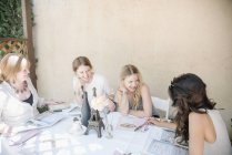 Quattro donne sorridenti sedute a un tavolo — Foto stock