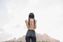 Vista trasera de una joven en topless - foto de stock