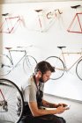 Homem que trabalha em uma oficina de reparação de bicicletas — Fotografia de Stock