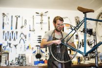 Mann repariert in Fahrradgeschäft. — Stockfoto