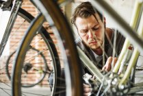 Чоловік ремонтує велосипед — стокове фото