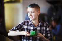 Young persion carrying a cup of coffee. — Stock Photo