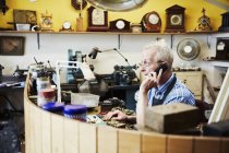 Clockmaker talking on the phone — Stock Photo