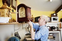 Clockmaker showing a clock — Stock Photo