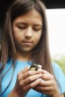 Молода дівчина тримає маленького дикого птаха — стокове фото