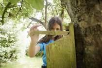Menina verificando uma caixa de aninhamento em um tronco de árvore . — Fotografia de Stock