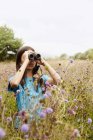 Girl holding binoculars — Stock Photo