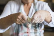 Donna sbriciolando e setacciando farina bianca — Foto stock