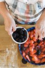 Mulher derramando frutas cozidas — Fotografia de Stock