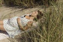 Mujer embarazada tumbada al sol - foto de stock