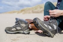 Mujer quitándose las botas de senderismo - foto de stock