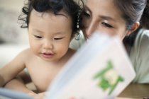 Mujer leyendo a un bebé - foto de stock