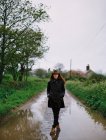 Donna che cammina su una strada bagnata — Foto stock