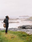 Woman lookng over the rocks — Stock Photo