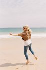 Женщина танцует босиком на песке — стоковое фото