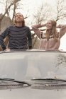 Молодая пара, стоящая в машине — стоковое фото