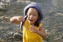 Giovane ragazza in possesso di un pesce . — Foto stock