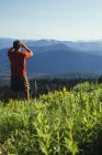 Homem de pé em um cume de montanha — Fotografia de Stock