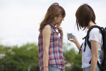 Japanese friends listening to music — Stock Photo