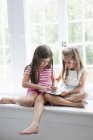 Duas meninas brincando com tablet digital . — Fotografia de Stock