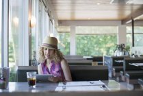 Mulher de chapéu sentada num restaurante — Fotografia de Stock